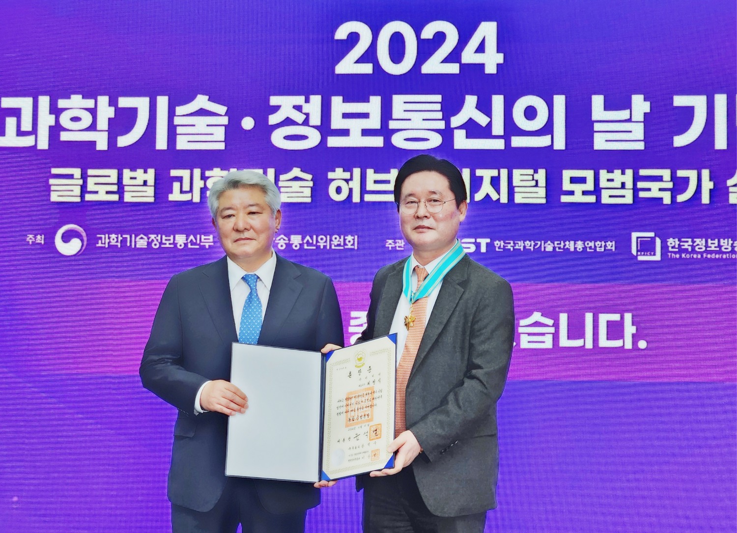 ▲더비엔 최정식 회장(오른쪽)이 ‘2024년 과학기술·정보통신의 날 기념식’에서 동탑산업훈장을 수훈하고 있다.