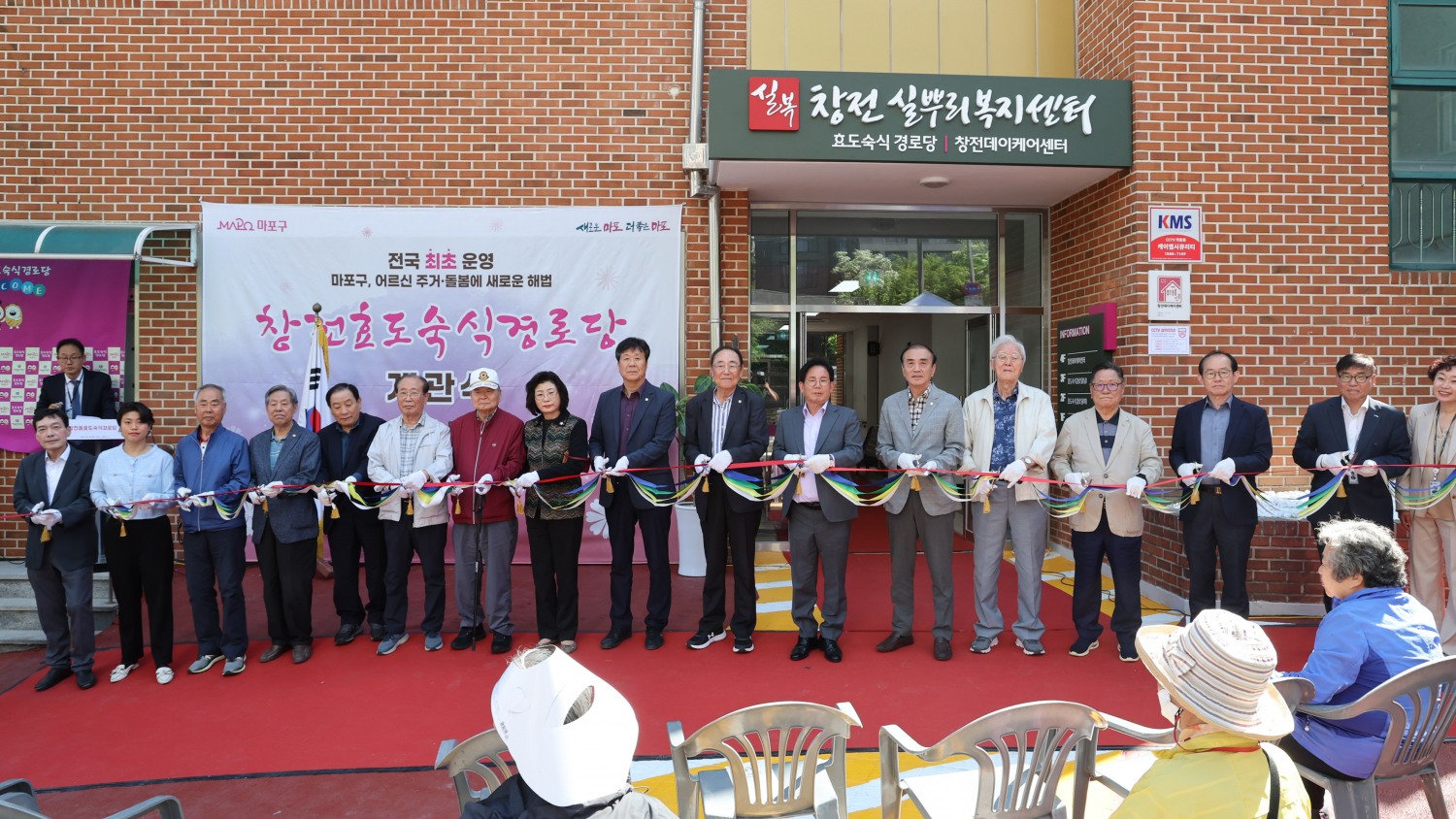 박강수 마포구청장(오른쪽에서 일곱번째)이 백남환 마포구의회 부의장(여덟번째)을 비롯한 관계자들과 창전 효도숙식 경로당의 개관식에서 기념촬영을 하는 모습./사진제공=마포구