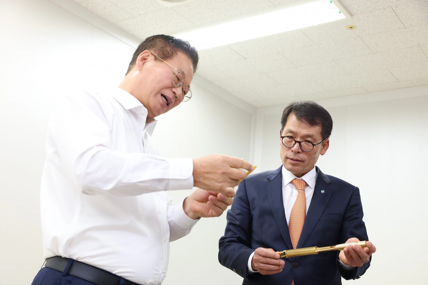 김성태 IBK기업은행장(오른쪽)이 9일 경기 성남산업단지에 소재한 하이콘을 방문해 황동원 대표에게 반도체 테스트 소켓에 대한 설명을 듣고 있다./사진제공=기업은행