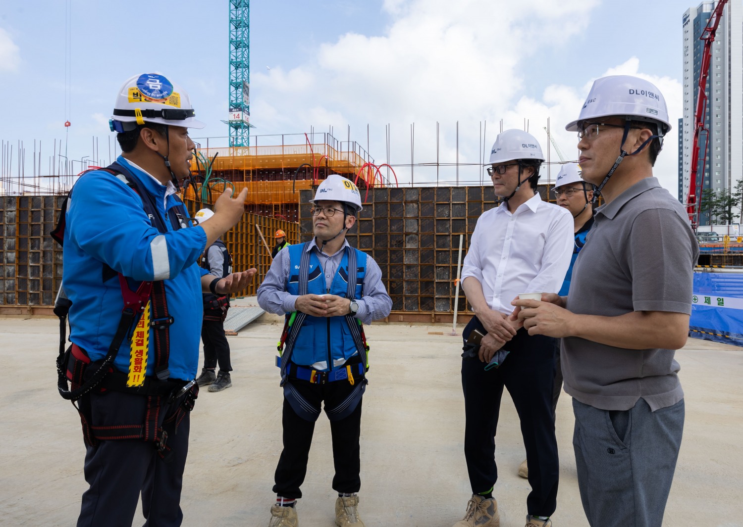 현장소장(좌측 첫번째)으로부터 이길포 CSO(좌측 두번째)와 자문위원들이 폭염대비 대책을 듣고 모습./사진제공=DL이앤씨