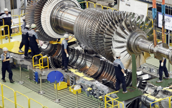 2019년 9월 두산에너빌리티 직원들이 가스터빈 초도호기 최종조립을 위해 로터 블레이드를 케이싱에 설치하고 있다. /사진제공=두산에너빌리티