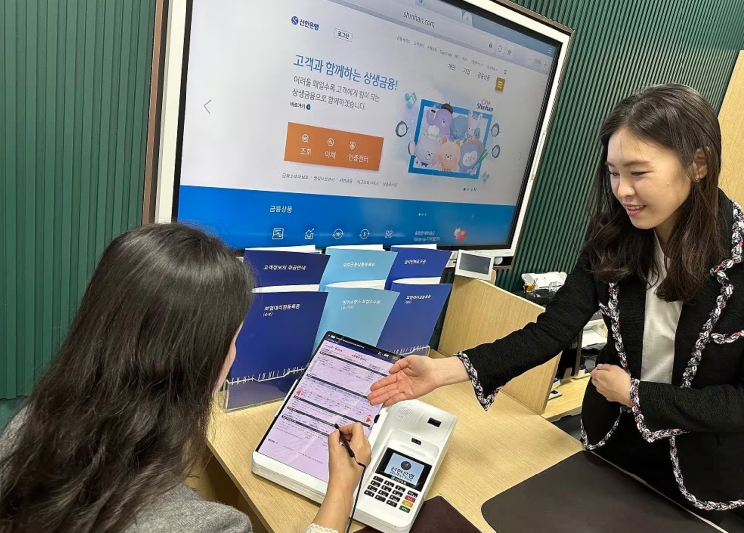 신한은행의 디지털 방카슈랑스 창구에서 고객이 보험 계약을 체결하고 있다./사진제공=신한은행