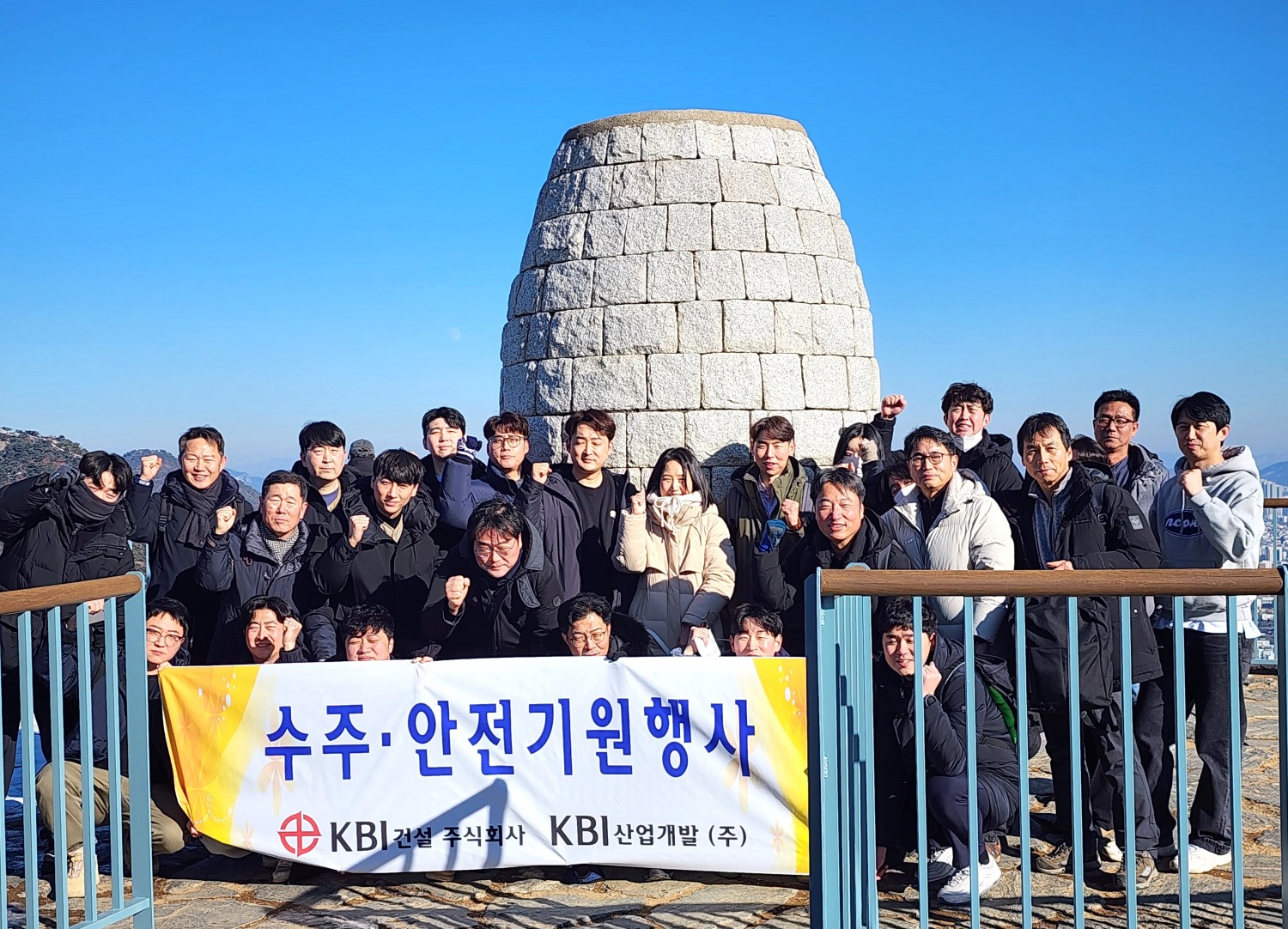 KBI건설 임직원들이 서울시 안산 정상에 올라 각오를 다지며 ‘파이팅’을 외치고 있는 모습./사진제공=KBI건설