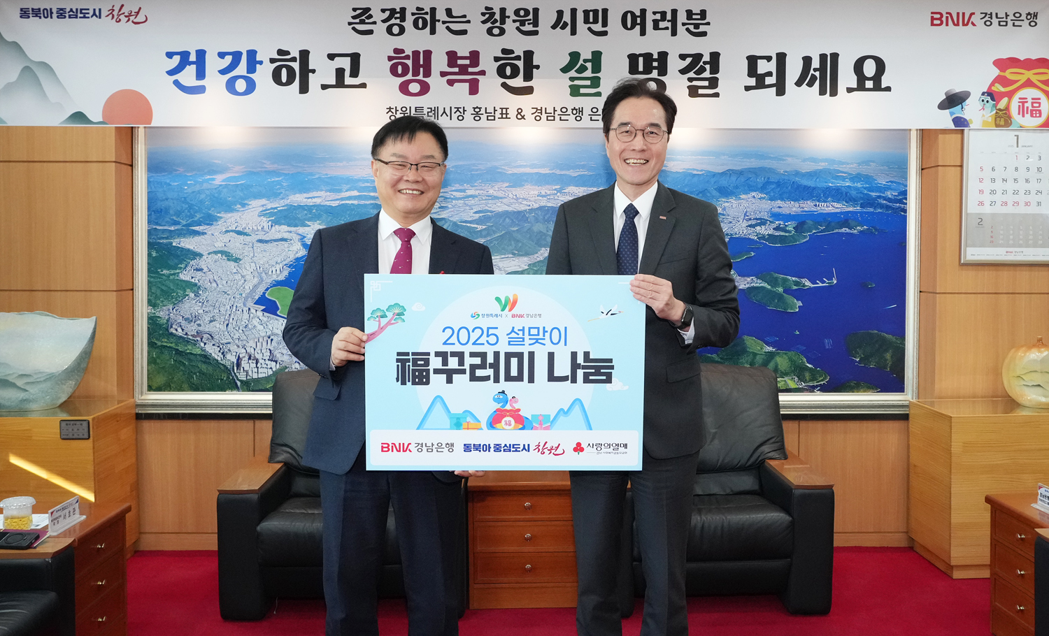 예경탁 BNK경남은행장(사진 오른쪽)이 홍남표 창원특례시장에게 ‘복꾸러미 기탁 증서’를 전달하고 있다./사진제공=경남은행