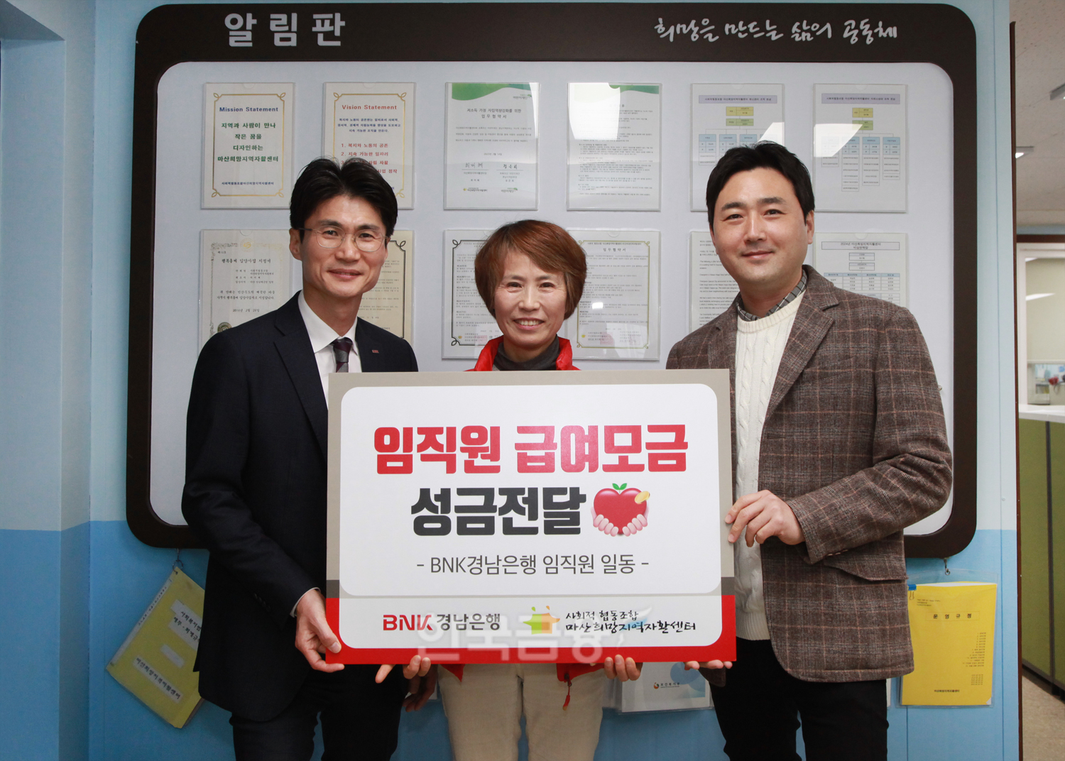 BNK경남은행 김지훈 팀장(사진 오른쪽 첫번째)과 신진욱 지점장이 마산희망지역자활센터 최미혜 센터장에게 ‘백합나눔회 성금 기탁 증서’를 전달하고 있다./ 사진 = BNK경남은행