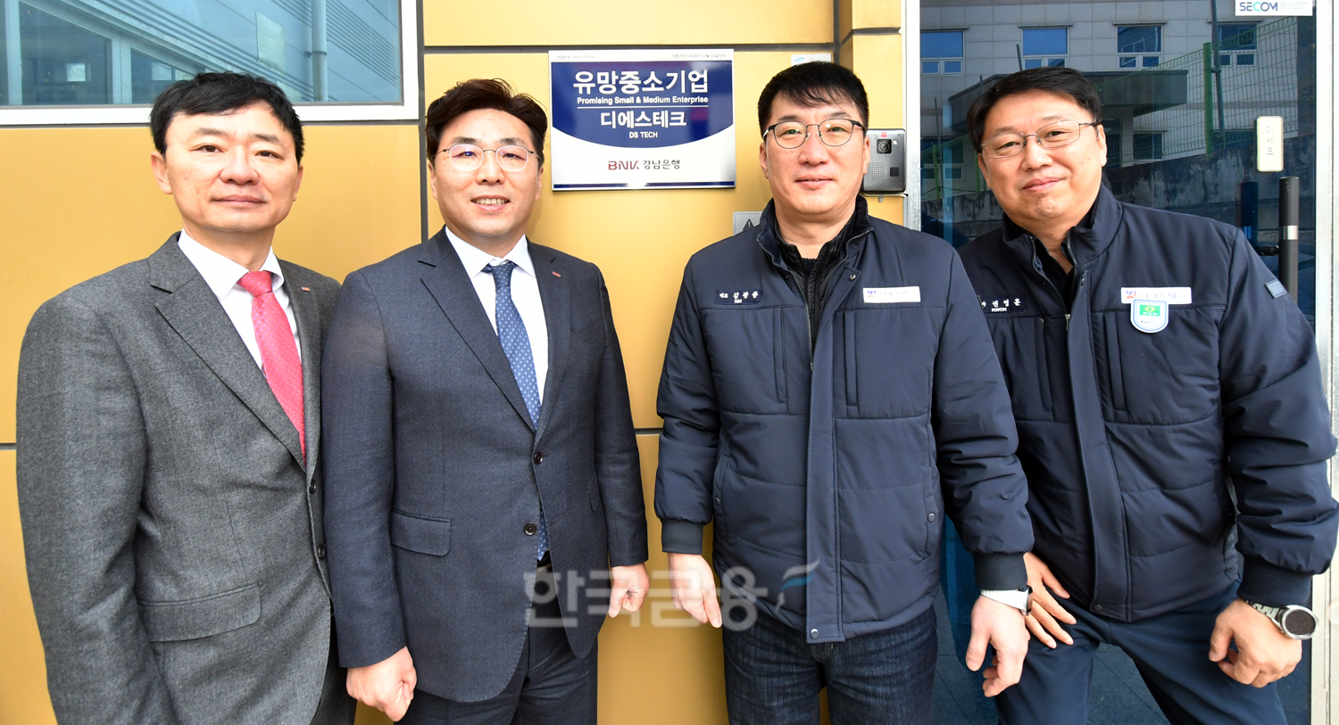 BNK경남은행 황재철 그룹장(사진 왼쪽 두번째)과 디에스테크 김광종 대표가 ‘유망중소기업 현판식’을 갖고 있다./ 사진 = BNK경남은행