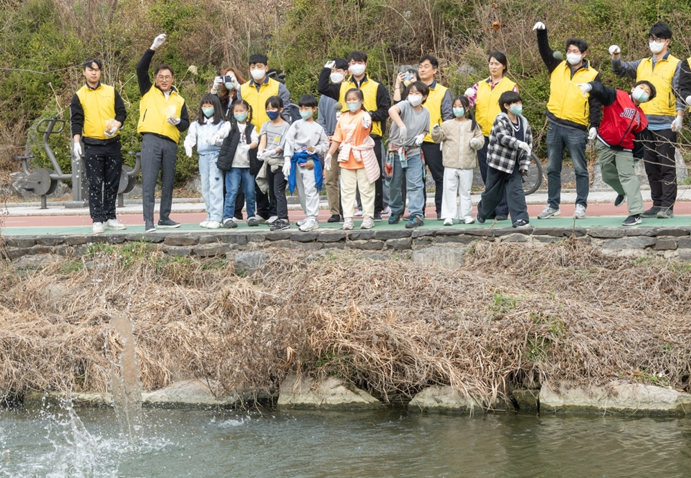 HDC현대산업개발 직원들과 지역주민들이 25일 서울 노원구 중랑천 일대에서 EM흙공을 직접 만들어 중랑천 주변에 던지고 있다. / 사진제공=HDC현대산업개발