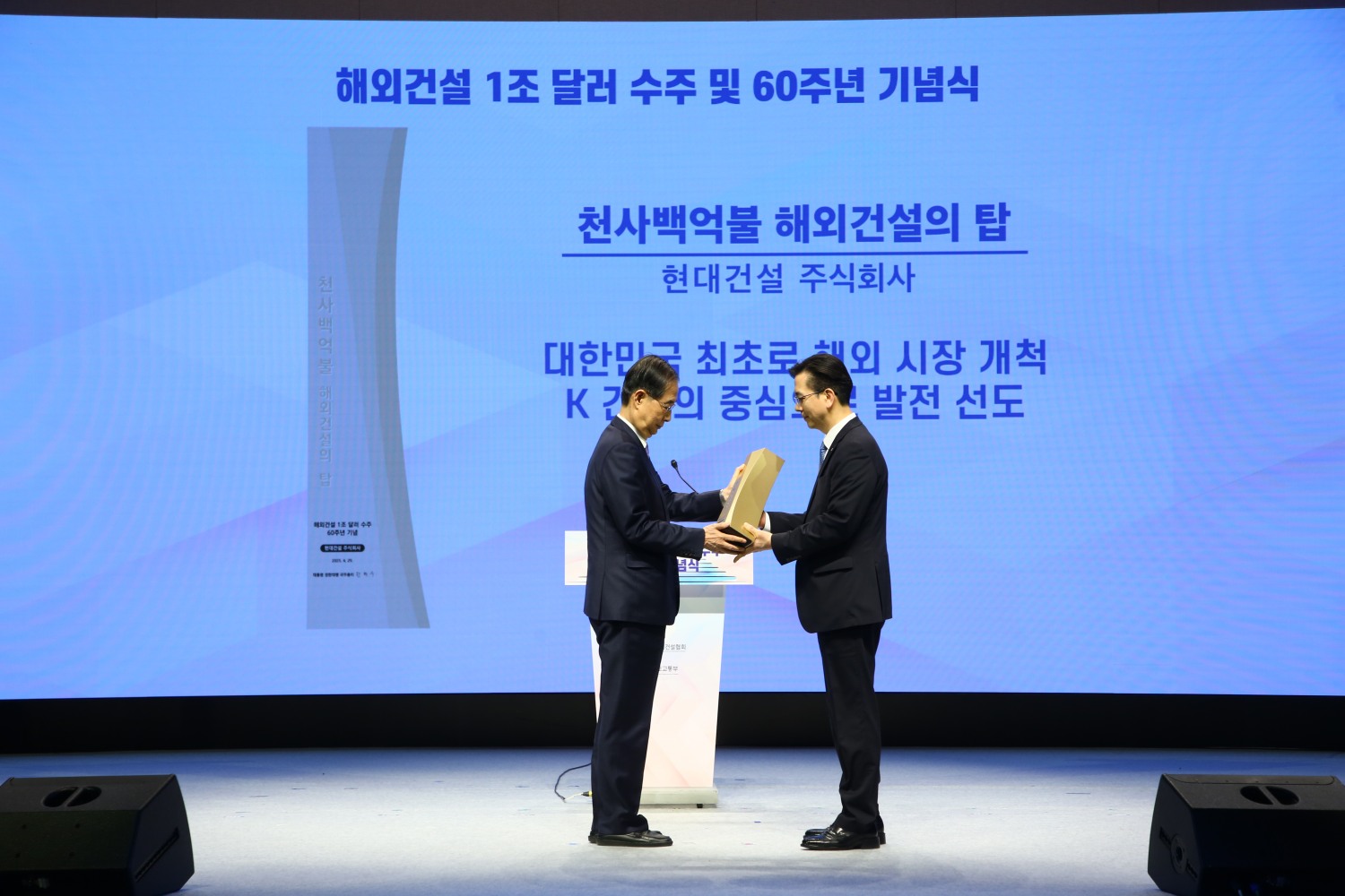 한덕수 대통령 권한대행 국무총리가 서울 강남구 건설회관에서 열린 '해외건설 1조 달러 수주 및 60주년 기념식'에서 이한우 현대건설 대표이사에게 해외건설의 탑을 수여하는 모습./사진제공=현대건설