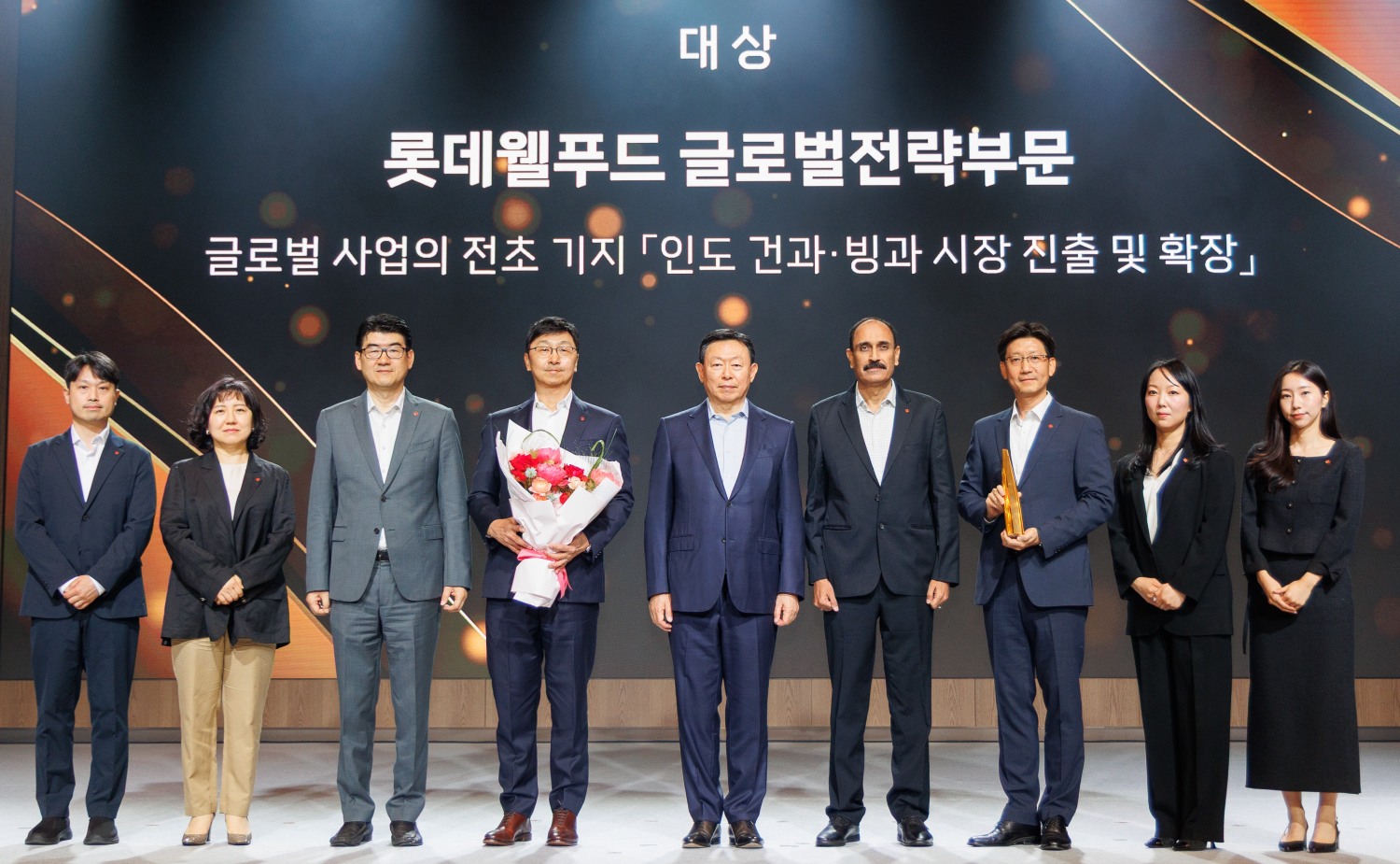 롯데가 12일 서울 송파구 롯데호텔 월드에서 ‘2025 롯데 어워즈’를 개최하고, 인도 시장 개척에 성과를 낸 롯데웰푸드를 대상으로 선정했다. 롯데 어워즈는 지난 한 해 동안 도전과 혁신정신으로 고객가치를 창출한 임직원들의 성과를 격려하고 시상하는 행사다. 롯데어워즈 대상을 시상한 신동빈 롯데 회장(사진 왼쪽에서 다섯 번째)과 수상자인 이창엽 롯데월푸드 대표. /사진제공=롯데