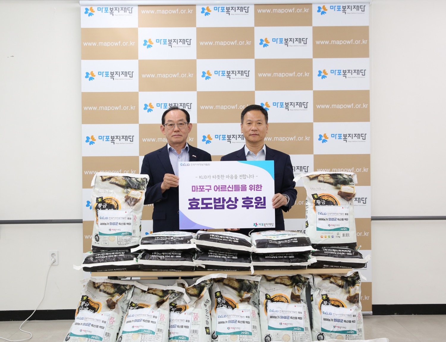 박덕수 한국지역정보개발원 원장(오른쪽)이 이홍주 마포복지재단 이사장과 마포 효도밥상식자재 기증식에서 기념촬영을 하는 모습./사진제공=한국지역정보개발원