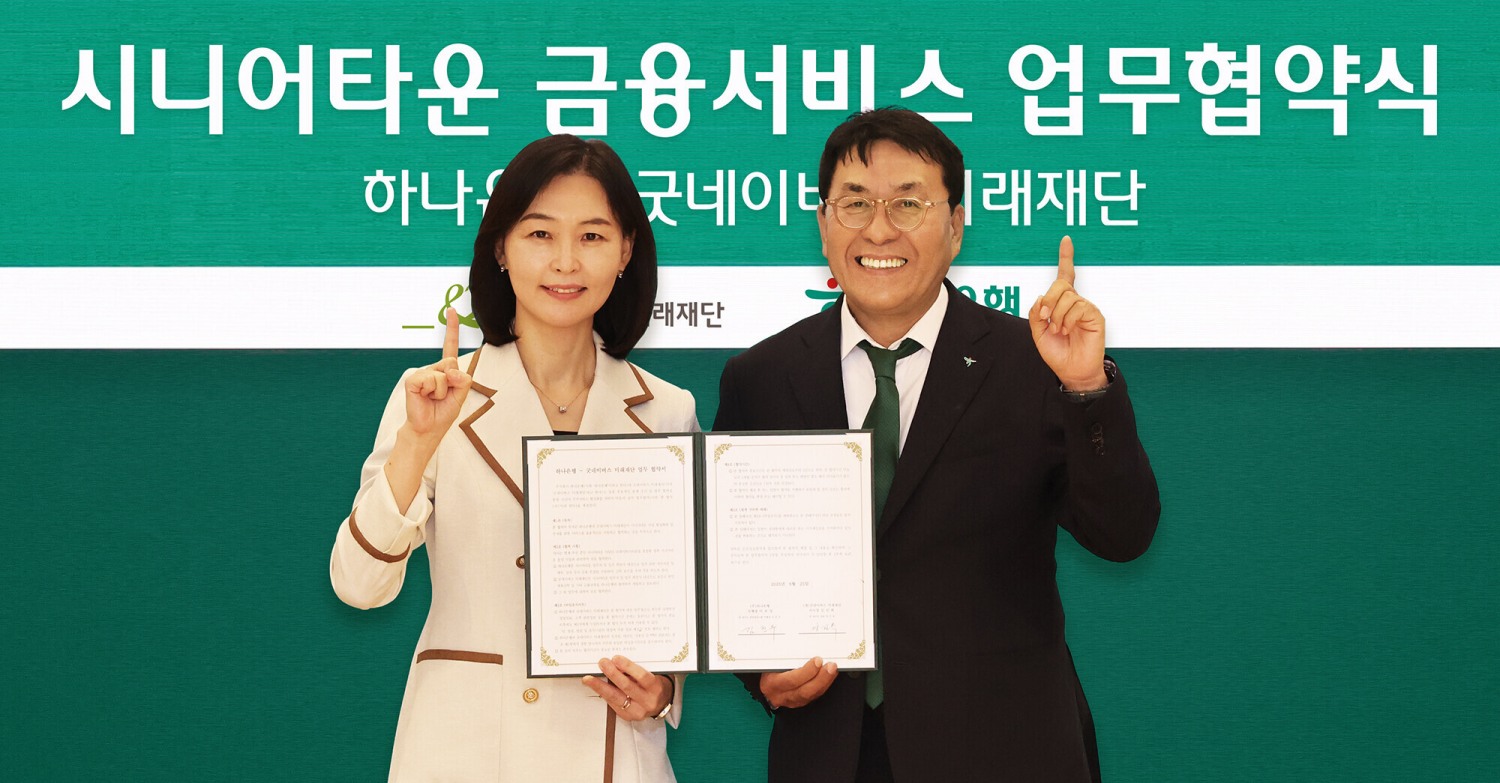 김진우 하나은행 중앙영업그룹 부행장(사진 오른쪽)이 양진옥 굿네이버스 미래재단 대표(사진 왼쪽)와 함께 업무협약서를 들고 기념 촬영을 하고 있다. / 사진제공=하나은행