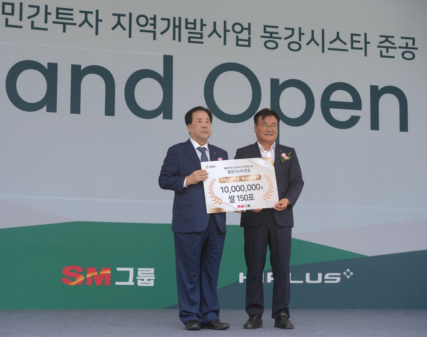 우오현 SM그룹 회장(왼쪽)과 최명서 영월군수가 지난 18일 강원 영월군 탑스텐 리조트 동강시스타 특설무대에서 열린 동강시스타CC 코스 증설 및 신규 클럽하우스 준공식에서 기념촬영을 하고 있다. 이날 준공식에서는 SM그룹이 영월군을 위해 마련한 쌀과 장학금을 전달하는 기부행사도 함께 열렸다. /사진제공=SM그룹