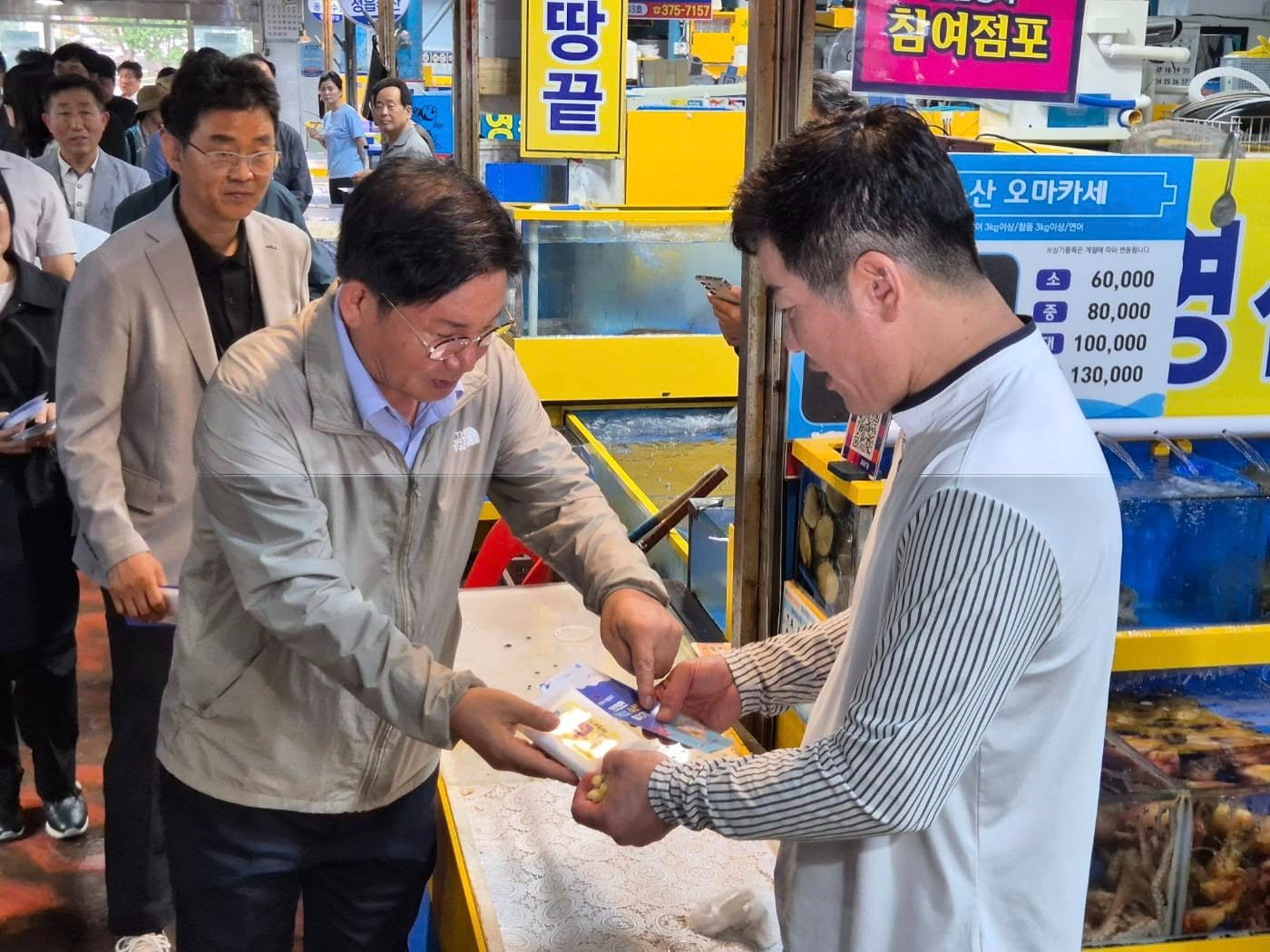 박강수 마포구청장이 마포농수산물시장에 방문해 상인에게 '안전한 여름철 수산물 즐기기 리플릿'을 배부하고 있다./사진제공=마포구