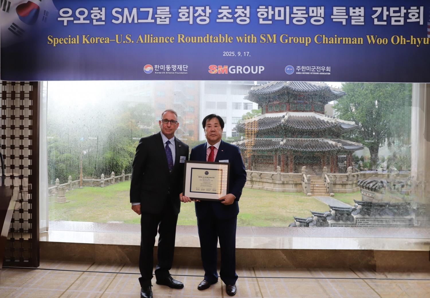 우오현 SM그룹 회장(오른쪽)이 지난 17일 서울 중구 웨스틴 조선 서울에서 열린 한미동맹 특별 간담회에서 로버트 에이브럼스 주한미군전우회장(전 한미연합사 사령관)에게 감사패를 받은 뒤 기념촬영을 하고 있다./사진제공=SM그룹