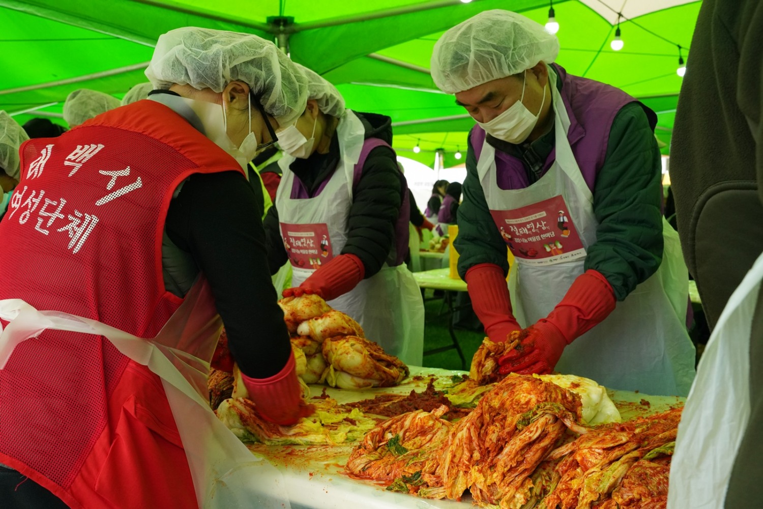 최철규 강원랜드 대표이사직무대행과 정선군 여성단체협의회 봉사자들이 정태영삼 김장나눔 어울림 한마당에서 김장을 하고 있는 모습./사진제공=강원랜드