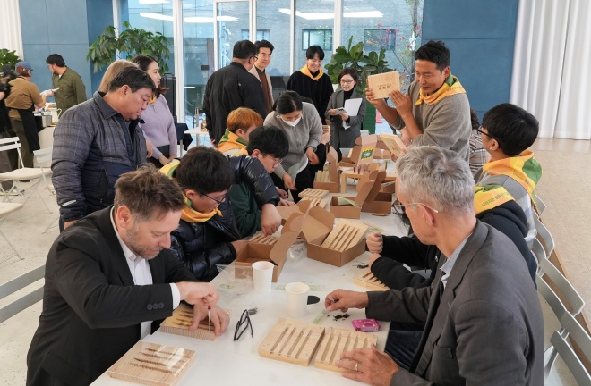 현대엔지니어링 '기프트하우스 플랜비: 벌, 집을 짓다' 전시회에서 참석자들이 야생벌집을 만들고 있다./현대엔지니어링