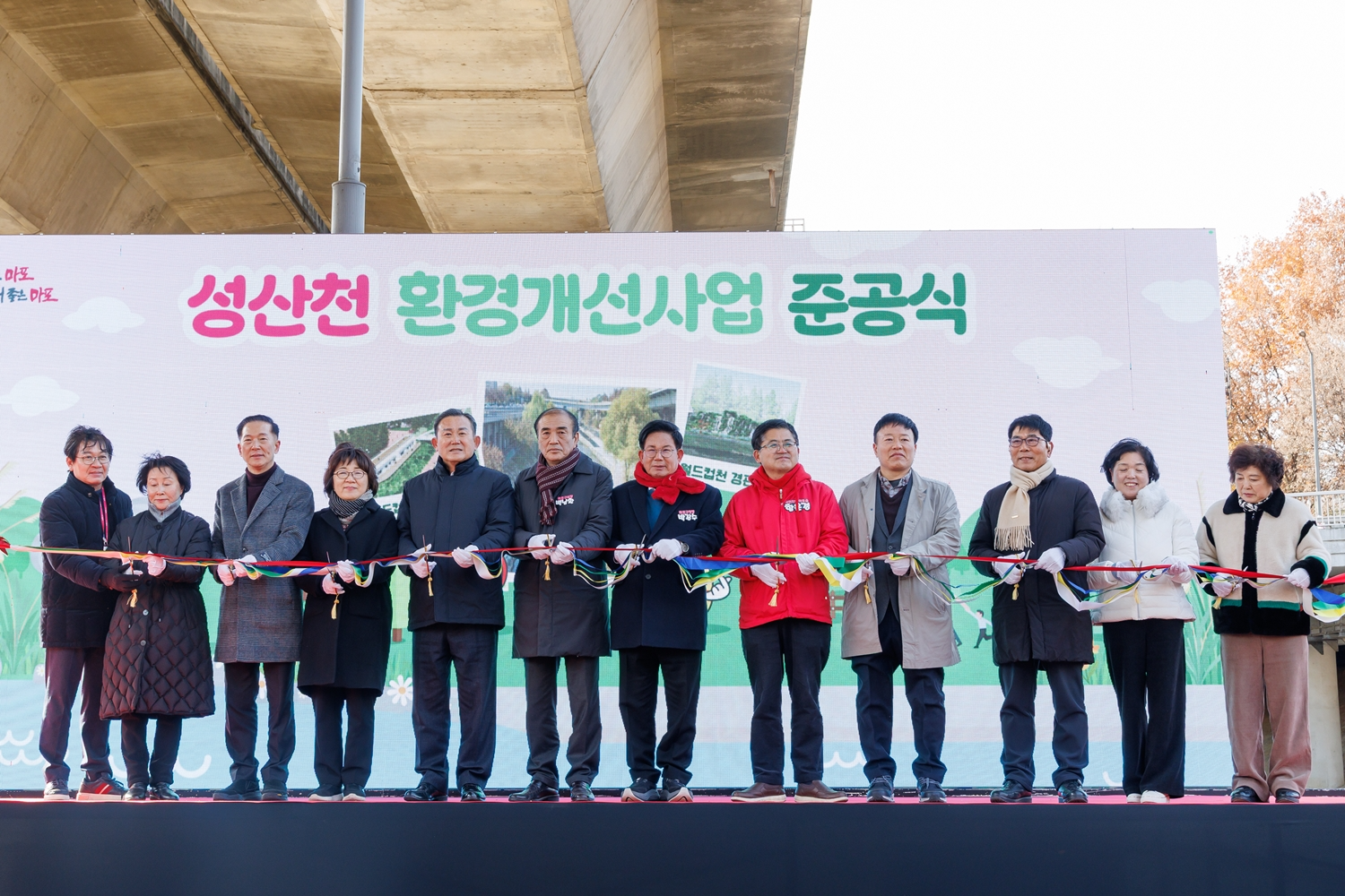 박강수 마포구청장(왼쪽에서 일곱번째)과 백남환 마포구의회 의장(여섯번째)을 비롯한 관계자들이 ‘성산천 환경개선사업 준공식’에 참석해 테이프 커팅식을 진행하는 모습./사진제공=마포구