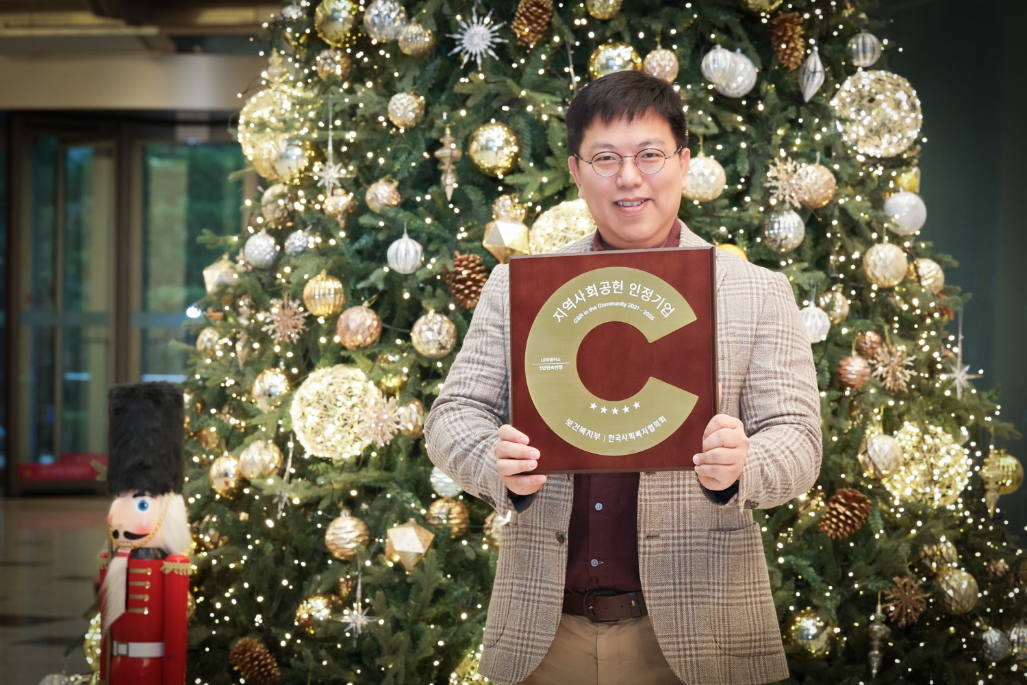 LG유플러스 직원이 지연사회공헌 인정 기관 상패를 소개하는 모습. / 사진=LG유플러스