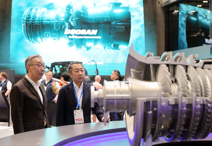 박정원 두산그룹 회장(오른쪽)과 박지원 그룹부회장(왼쪽)이 7일(현지시간) 미국 라스베이거스에서 열리고 있는 CES 2026 현장에서 두산 부스에 전시된 가스터빈 모형을 살펴보고 있다. /사진제공=두산그룹