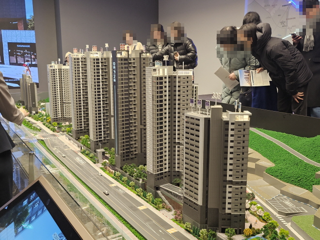 지난 SK에코플랜트의 '드파인 연희' 견본주택 모형도에서 방문객들이 단지 구성을 확인하고 있다./한국금융신문 조범형 기자