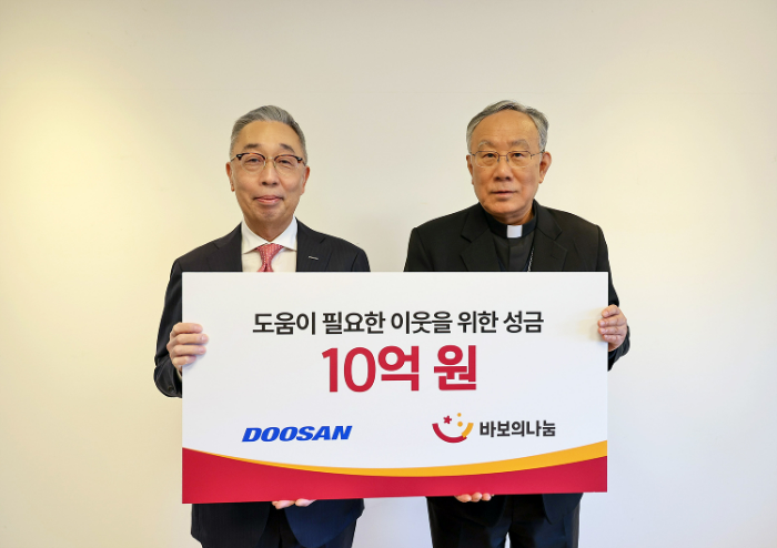 박지원 두산그룹 부회장(왼쪽)과 구요비 재단법인 바보의 나눔 이사장이 지난 3일 서울 명동성당에서 열린 성금 전달식에서 기념촬영을 하고 있다. /사진제공=두산그룹