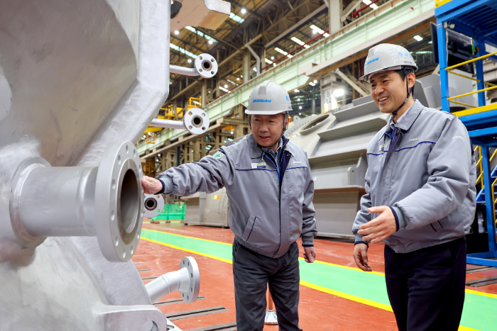 박정원 두산그룹 회장(왼쪽)이 지난 11일 경남 창원 두산에너빌리티 사업장을 방문해 제작 중인 발전용 가스터빈 제품을 살펴보고 있다. /사진제공=두산