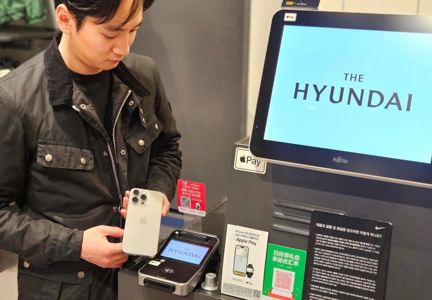 현대백화점 직원이 '애플페이'를 시현해 보이고 있는 모습./사진제공=현대백화점