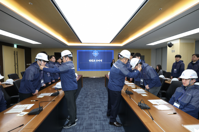 김보현 대표이사와 심상철 노동조합 위원장이 신입사원에게 안전모를 씌워주고 있다./사진제공=대우건설