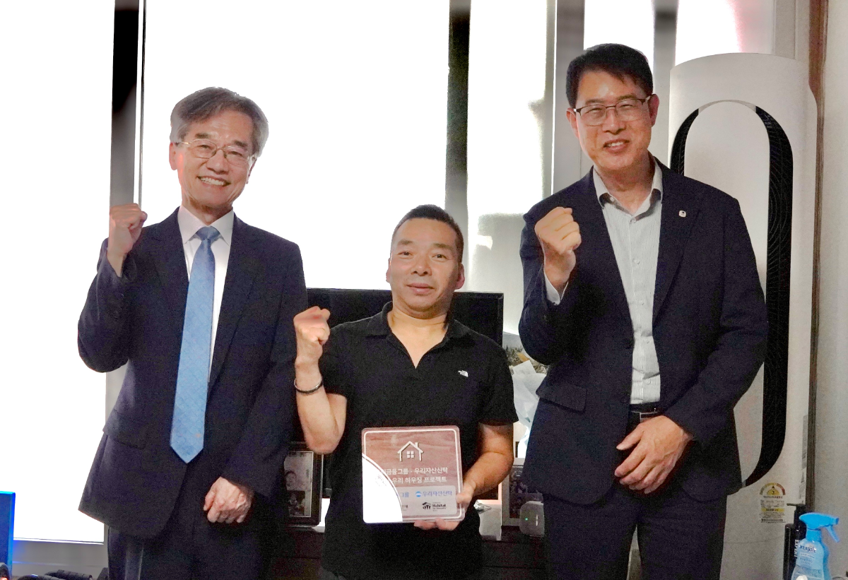 우리자산신탁이 지난달 29일 한국해비타트와 함께 주거 취약계층의 주거환경 개선을 위한 사회공헌사업인 ‘With우리 하우징 프로젝트’를 성공적으로 마무리하고, 사업 완공을 기념하는 헌정식을 개최했다.김범석 우리자산신탁 대표이사(사진 오른쪽), 이광회 한국해비타트 사무총장(사진 왼쪽)이 'With우리 하우징' 고객과 함께 기념촬영을 하고 있다. /사진제공=우리자산신탁