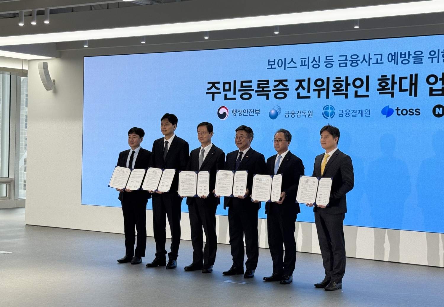 (왼쪽부터) 박상진 네이버페이 대표, 이승건 비바리퍼블리카(토스) 대표, 이찬진 금융감독원장, 윤호중 행정안전부 장관, 채병득 금융결제원장, 신원근 카카오페이 대표가 9일 오후 1시 토스 신논현 오피스에서 열린 '주민등록증 진위 확인 확대를 위한 업무협약(MOU)'에서 협약서를 들고 기념 사진을 찍고 있다. 사진=강혜린 기자