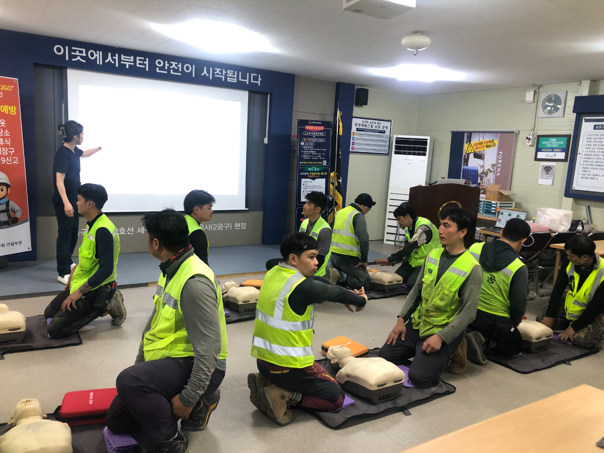 외국인 근로자들이 상황에 맞춰 자동심장충격기(AED)를 사용하고 있다. /사진제공=한화 건설부문