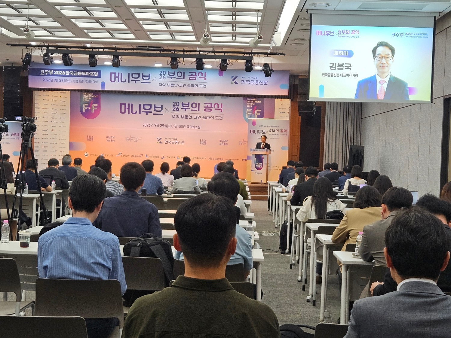 한국금융신문이 29일 서울 명동 은행회관 국제회의실에서 '2026 한국금융투자포럼'을 개최했다. 김봉국 한국금융신문 대표이사의 개회사와 함께, 포럼을 청취하는 참석자들. / 사진= 한국금융신문(2026.09.29)