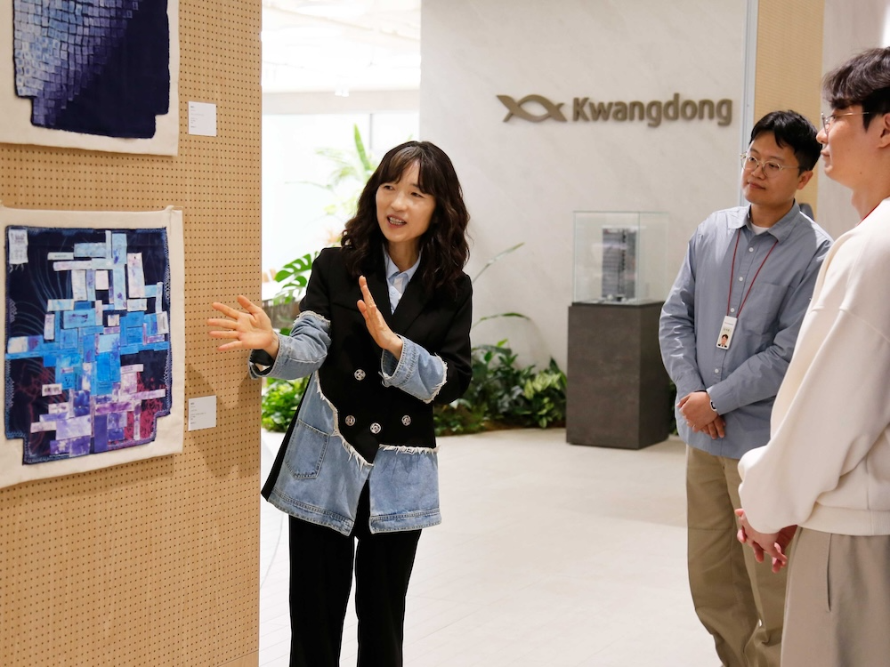 정은진 광동제약 정은진 ESG 위원장이 직원들에게 전시 작품을 설명하는 모습. /사진=광동제약