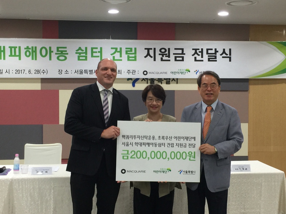 칼 자콥슨 맥쿼리투자신탁운용 대표가 28일 이제훈 어린이재단회장에게 서울시 학대피해아동쉼터 지원금 2억원을 전달하고 있다.