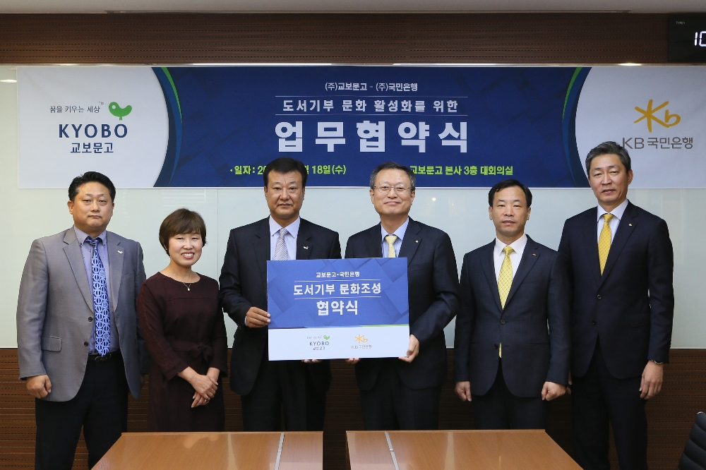 △신홍섭 KB국민은행 소비자브랜드전략그룹대표(왼쪽 네 번째)와 김형면 교보문고 점포사업본부장(왼쪽 세 번째)이 업무협약 후 관계자들과 기념촬영하고 있다./사진=KB국민은행
