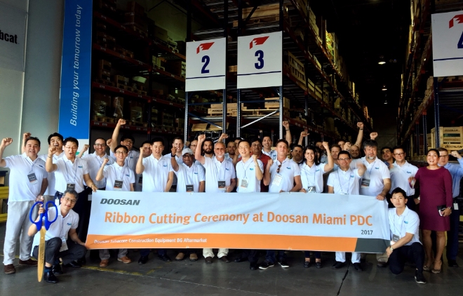 두산인프라코어 임직원들이 미국 마이애미 부품공급센터에서 오픈 기념식을 갖고 본격 운영을 시작했다. 사진=두산인프라코어.
