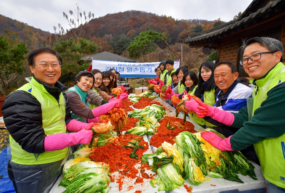 △우광혁 NH농협카드 부사장(좌)과 우민제 파주 초리골마을 이장(우측에서 두 번째) 및 마을 주민들, NH농협카드 직원이 함께 김장을 담그고 있다./사진=NH농협카드