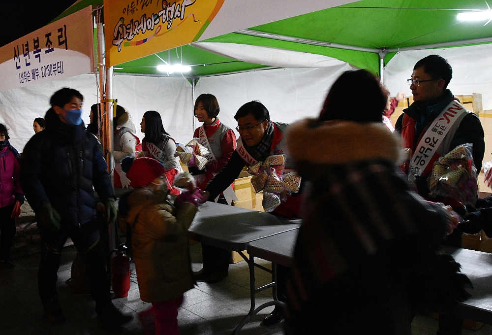 △BNK경남은행 울산지역 봉사대가 '2017년 송년 제야 행사'에 참가한 시민들에게 복조리를 나눠주고 있다./ 사진=경남은행