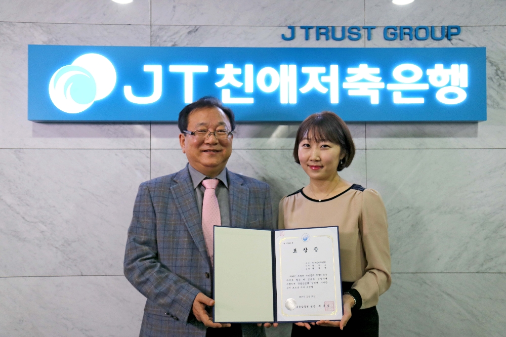 △(왼쪽부터) 윤병묵 JT친애저축은행 대표이사와 최빛나 경영본부 과장보가 표창장을 들고 기념촬영을 하고 있다./사진=JT친애저축은행