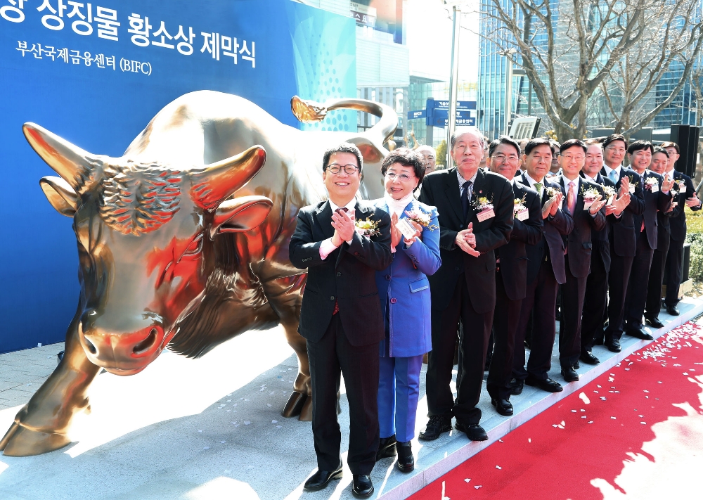정지원 한국거래소 이사장(맨 앞)과 제막식 참석인사들이 KRX 황소상 앞에서 기념촬영을 하고있다.