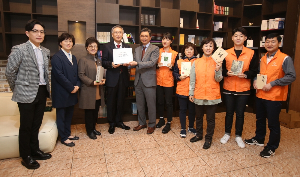 △행복한 경제도서관 현판을 전달한 후 한화생명 서지훈 상무(왼쪽에서 5번째), 꽃동네대학교 황선대 총장(왼쪽에서 4번째) 등 한화그룹 금융계열사 임직원 및 꽃동네대학교 관계자들이 기념촬영을 하고 있다. / 사진=한화생명