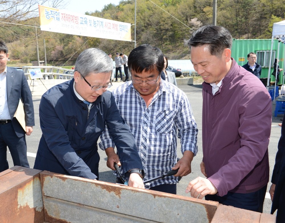 △NH농협손보 오병관 대표이사(왼쪽)와 농협중앙회 조소행 충남지역본부장(오른쪽)이 농업인에게 경운기 안전반사판 부착 방법을 설명하고 있다. / 사진=NH농협손해보험