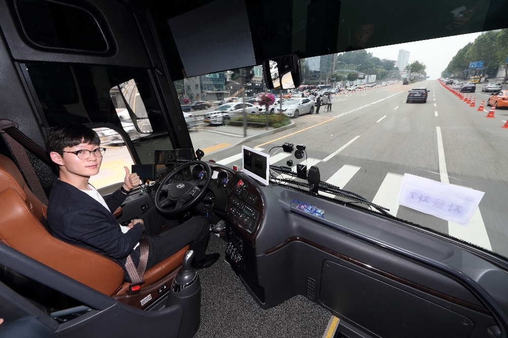 △KT 자율주행 버스 운전자가 영동대로를 주행하는 도중 양손이 자유로운 상황에서 기념 촬영을 하고 있다 / 사진=KT