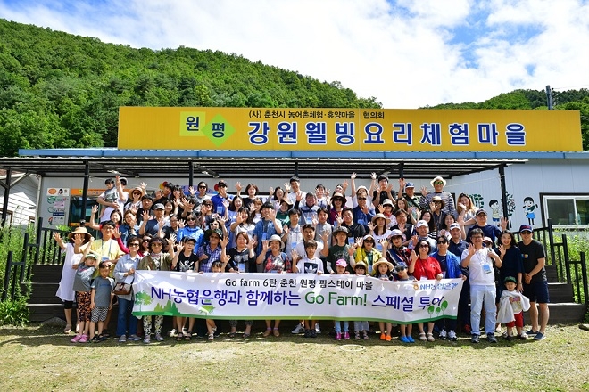 NH농협은행 임직원들과 '농촌체험여행' 이벤트 당첨자들이 강원도 춘천 원평 팜스테이마을에서 단체 사진을 찍고 있다. / 사진 = NH농협은행