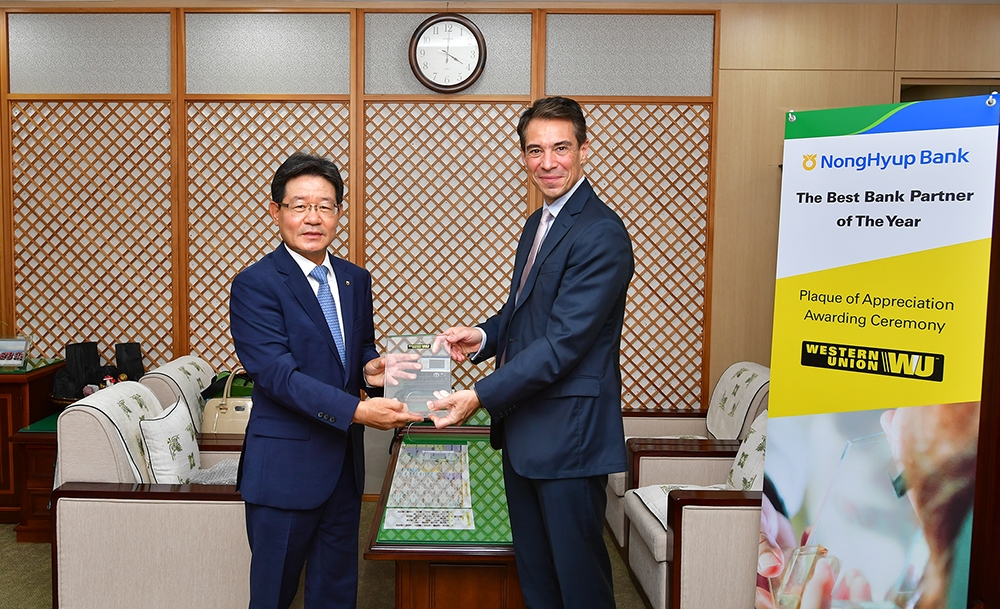 웨스턴 유니온 오딜롱 알메이다(Odilon Almeida) 해외송금 총괄사장(오른쪽)이 24일 농협은행 본사를 찾아 유윤대 부행장(왼쪽)에게 감사패를 수여하고 있다. / 사진= 농협은행