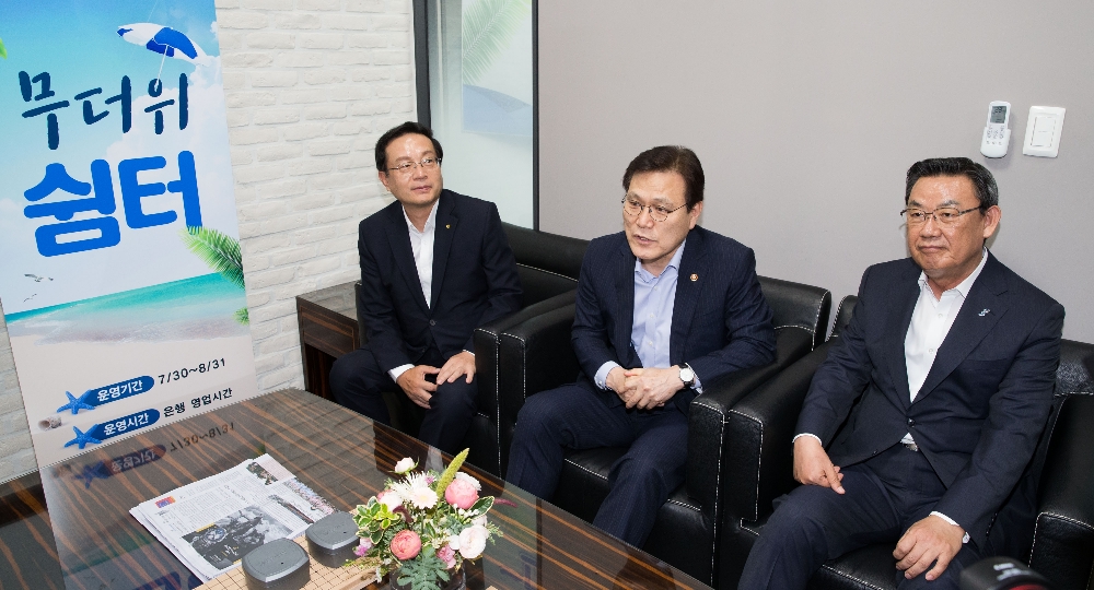 최종구 금융위원장(사진 가운데)은 30일 서울 종로구 우리은행 YMCA지점에 무더위 쉼터를 방문해 직원들을 격려했다. 최종구 금융위원장이 은행점포 내 무더위 쉼터를 이용중인 고객들과 이야기를 하고 있다. 왼쪽부터 손태승 우리은행장, 최종구 금융위원장, 김태영 은행연합회장. / 사진= 금융위원회