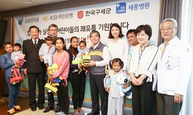 윤석헌 금감원장과 허인 KB국민은행장은 30일 부천 세종병원을 방문해 ‘캄보디아 심장병 어린이 의료 지원’ 사업을 통해 국내에서 수술을 마치고 회복중인 어린이들을 격려했다.(사진 왼쪽 3번째)김필수 한국구세군사령관, (사진 왼쪽 5번째)허인 KB국민은행장, (사진 왼쪽 9번째)윤석헌 금융감독원장, (사진 왼쪽 10번째)심석희 KB금융그룹 후원선수, (오른쪽 첫번째)이명묵 세종병원장. / 사진 = KB국민은행