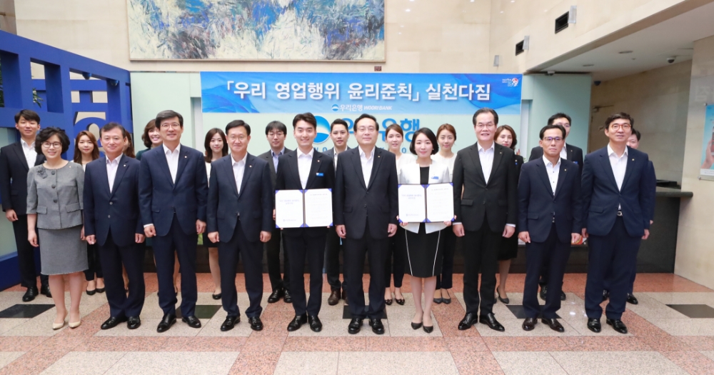 우리은행은 31일 서울시 중구 본점에서 금융소비자권익 보호를 위한 '영업행위 윤리준칙' 실천 다짐 행사를 실시했다. 실천 다짐 후 손태승 은행장(사진 앞줄 왼쪽 여섯번째)과 임직원 모습. / 사진= 우리은행