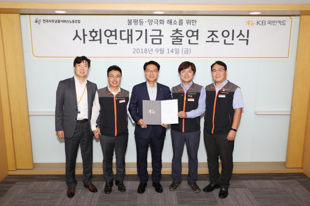 △14일 오후 서울 종로구 KB국민카드 본사에서 열린 불평등 및 양극화 해소를 위한 ‘사회연대기금 출연 조인식’에서 이동철 KB국민카드 사장(왼쪽에서 세번째)과 김현정 전국사무금융서비스노동조합 위원장(왼쪽에서 네번째), 이경진 전국사무금융서비스노동조합 KB국민카드지부장(왼쪽에서 두번째)이 기념 촬영을 하고 있다./사진=KB국민카드