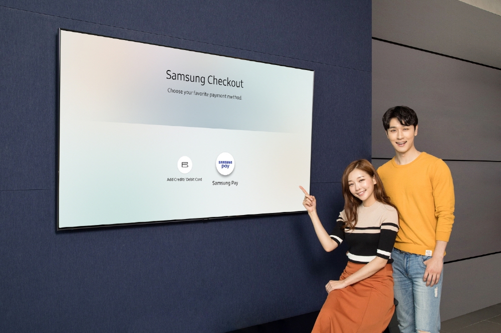 △삼성디지털프라자 용인 구성점에서 모델들이 2018년형 삼성 QLED TV에 탑재된 T-커머스 전용 결제 시스템 ‘삼성 체크아웃’에 새롭게 도입되는 ‘삼성페이’ 간편결제 서비스를 소개하고 있다